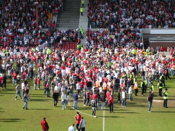 Town fans storm the pitch after promotion is confirmed.